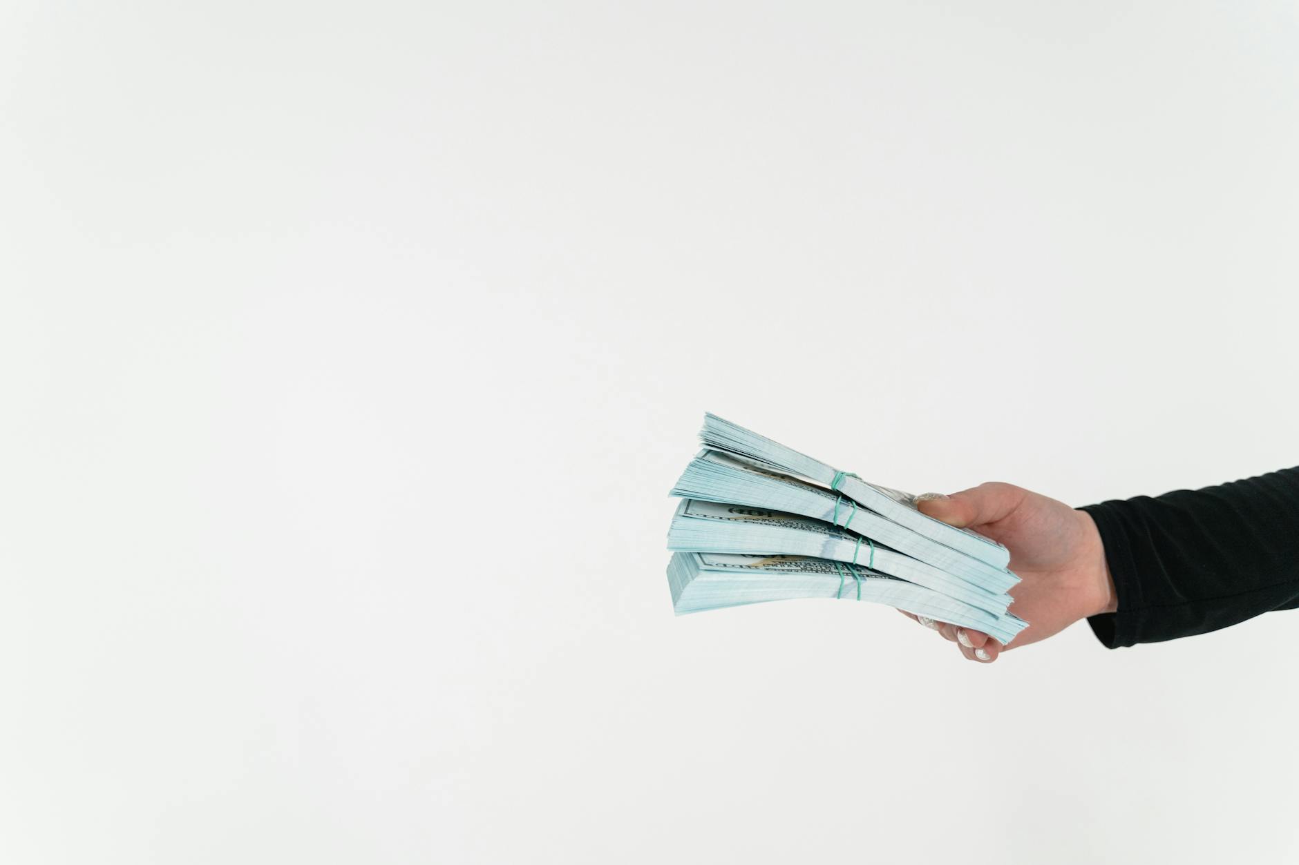 a person holding bundles of cash money
